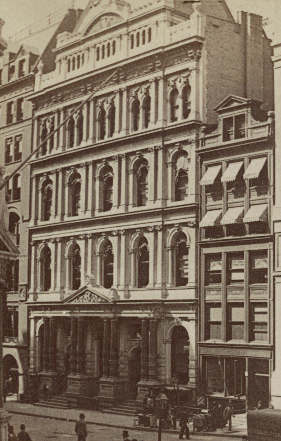 The New York Stock Exchange at 10-12 Broad Street in 1896: a five-storey
                  marble facade with tiers of paired arched windows on colonnettes, a
                  columned portico at street level, and pedestrians and a wagon below